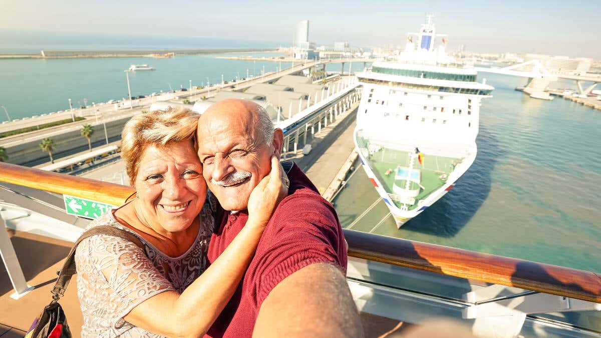Pareja se toma un selfie frente a crucero. 