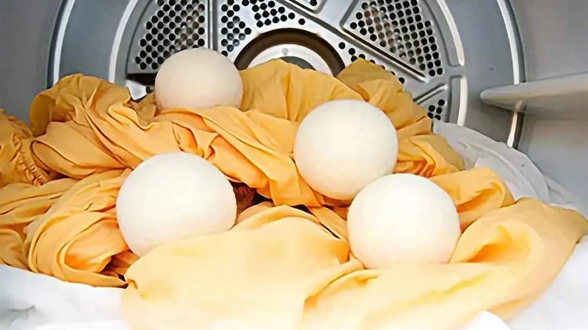 Bolas de lana dentro de una secadora con ropa.