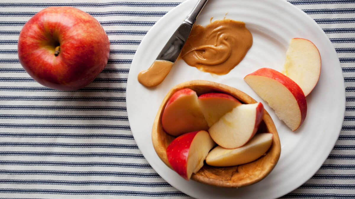 Trozos de manzana con mantequilla de almendras. 