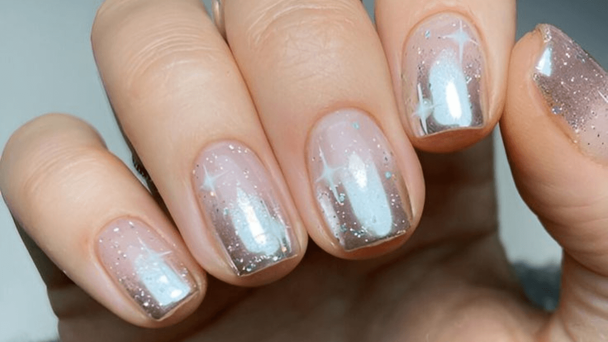 Unhas nude com toques de glitter.