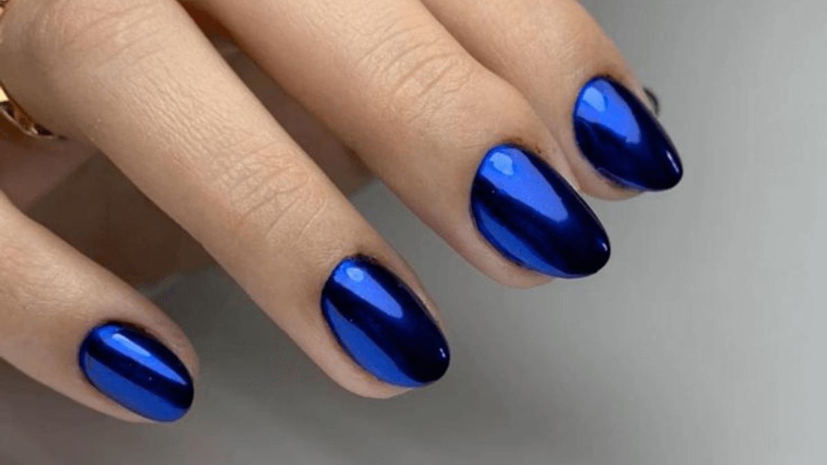 Unhas pintadas com efeito espelho em azul cobalto.