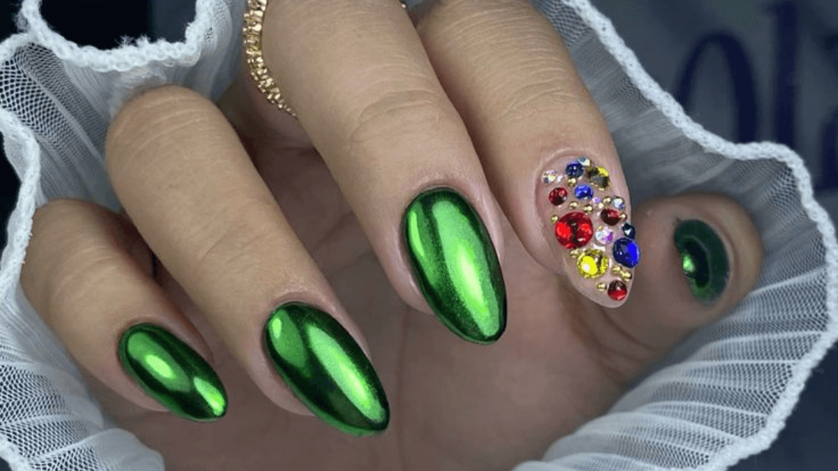 Uñas verdes con efecto espejo y pedrería dedo índice.