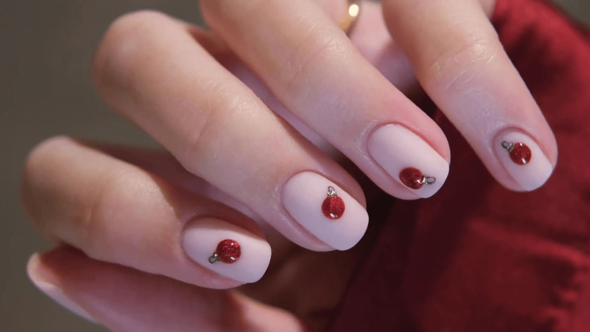 Unhas curtas com esferas de Natal.