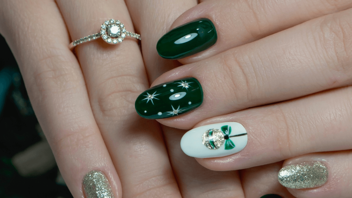 Unhas pintadas de verde, branco e glitter.