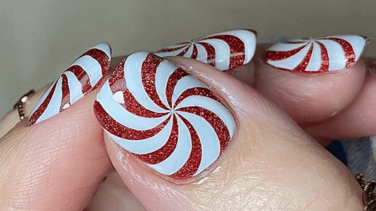 Uñas con diseño de bastones de caramelo navideño.