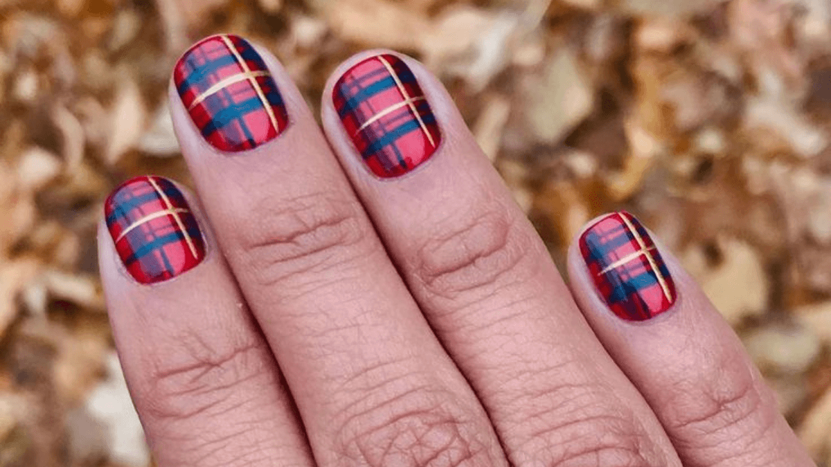Unhas com design escocês.