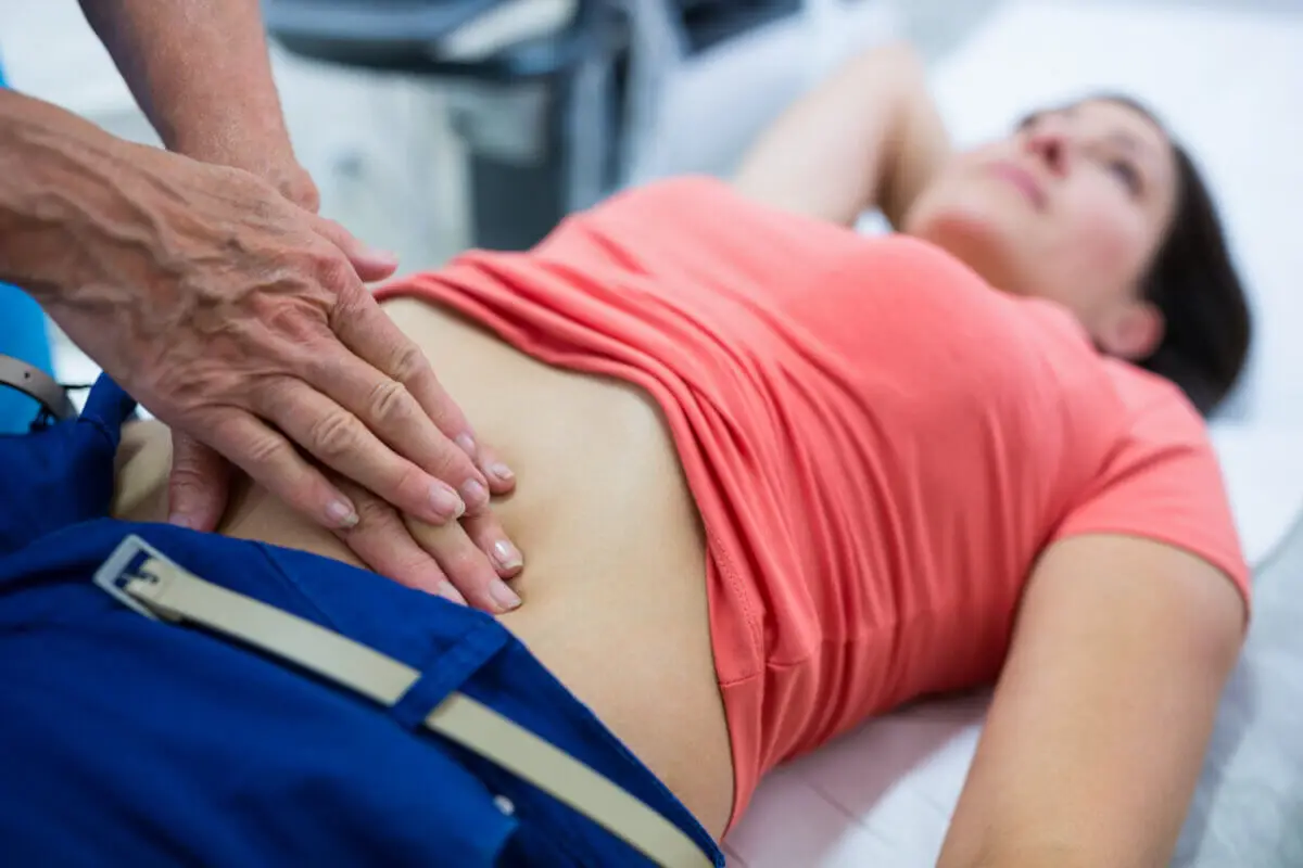 Mujer siendo presionada en el abdomen por mareo