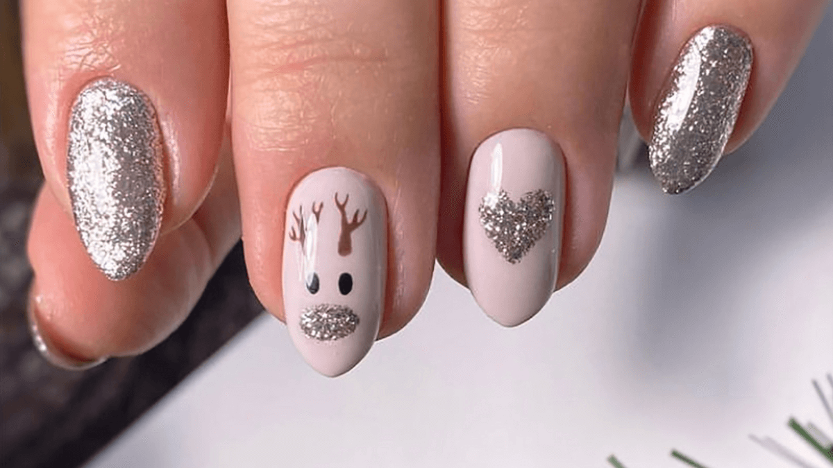 Unhas curtas com desenho de renas e glitter.