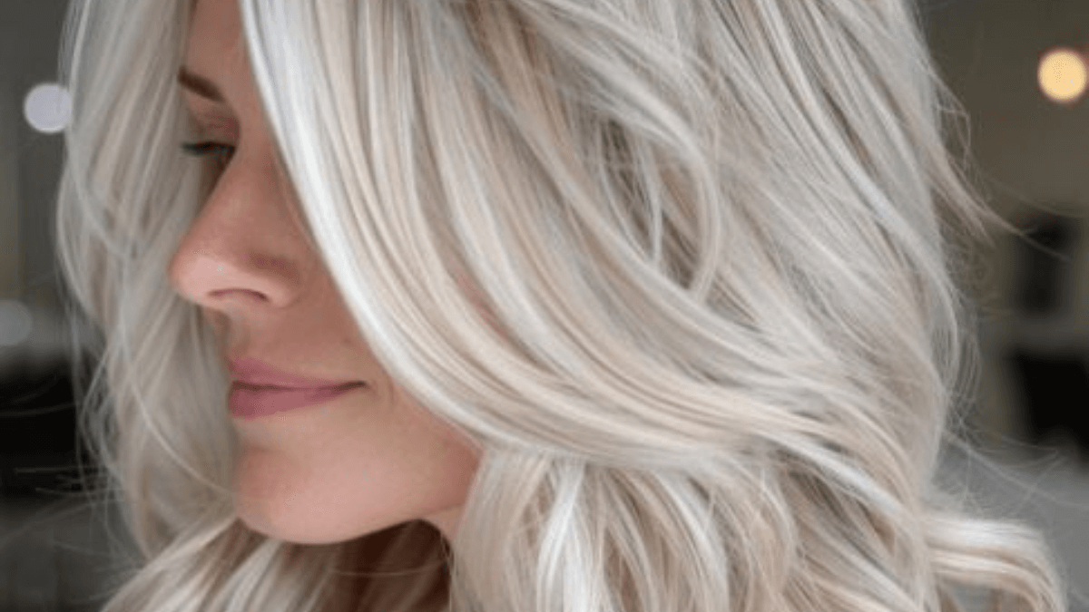 Perfil de uma mulher com cabelo loiro gelado.