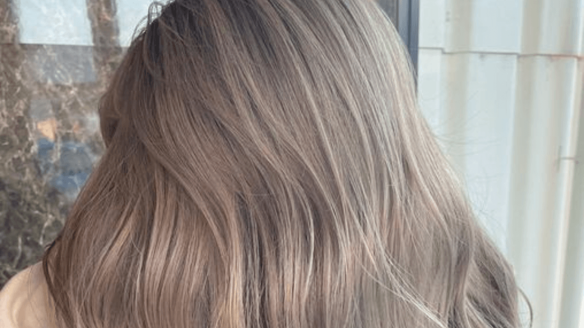 Cabello con tono rubio polvo.