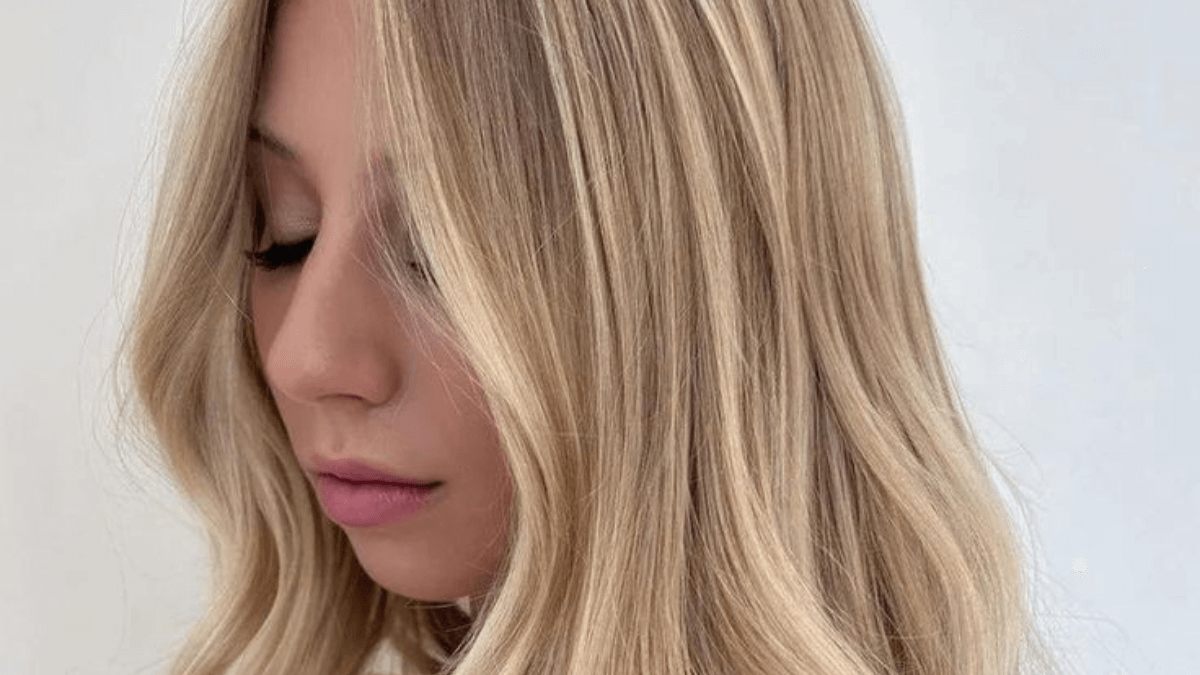 Mujer de perfil con tono de rubio vainilla.