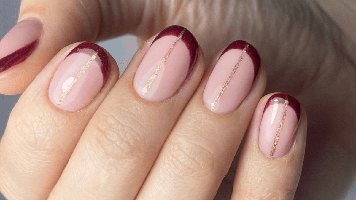 Vinho francês tinto e unhas brilhantes.