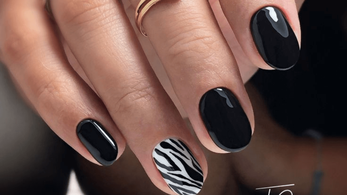 Uñas negras con un diseño de cebra.