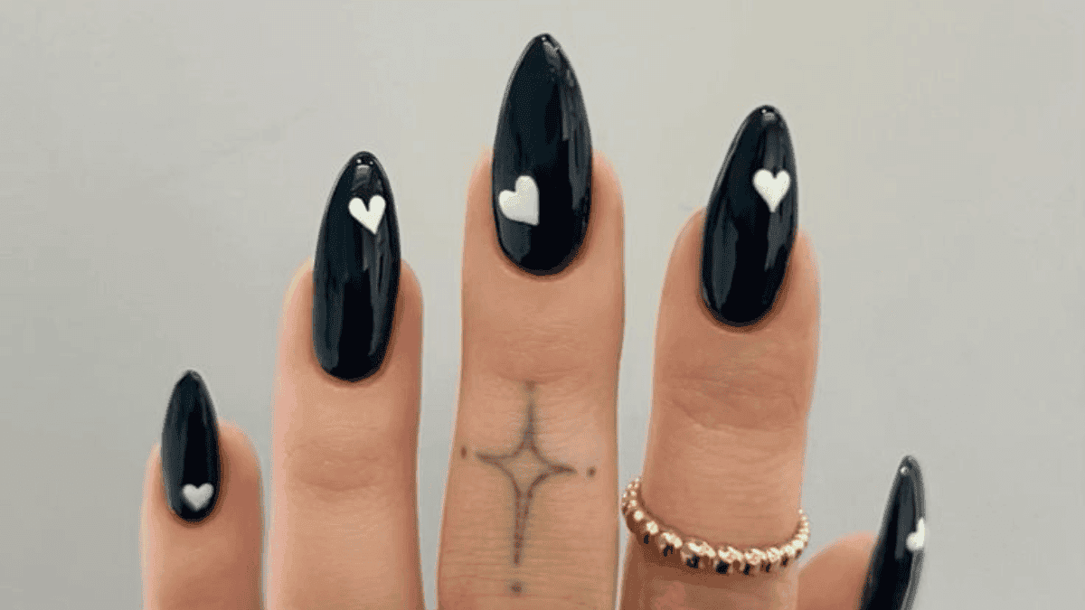 Uñas negras con corazones blancos.