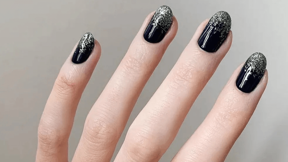Uñas negras con plateado en las puntas.