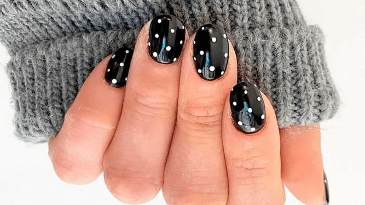 Uñas negras con puntos blancos.