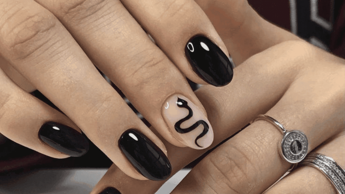Uñas negras un dedo índice con el diseño de una serpiente.