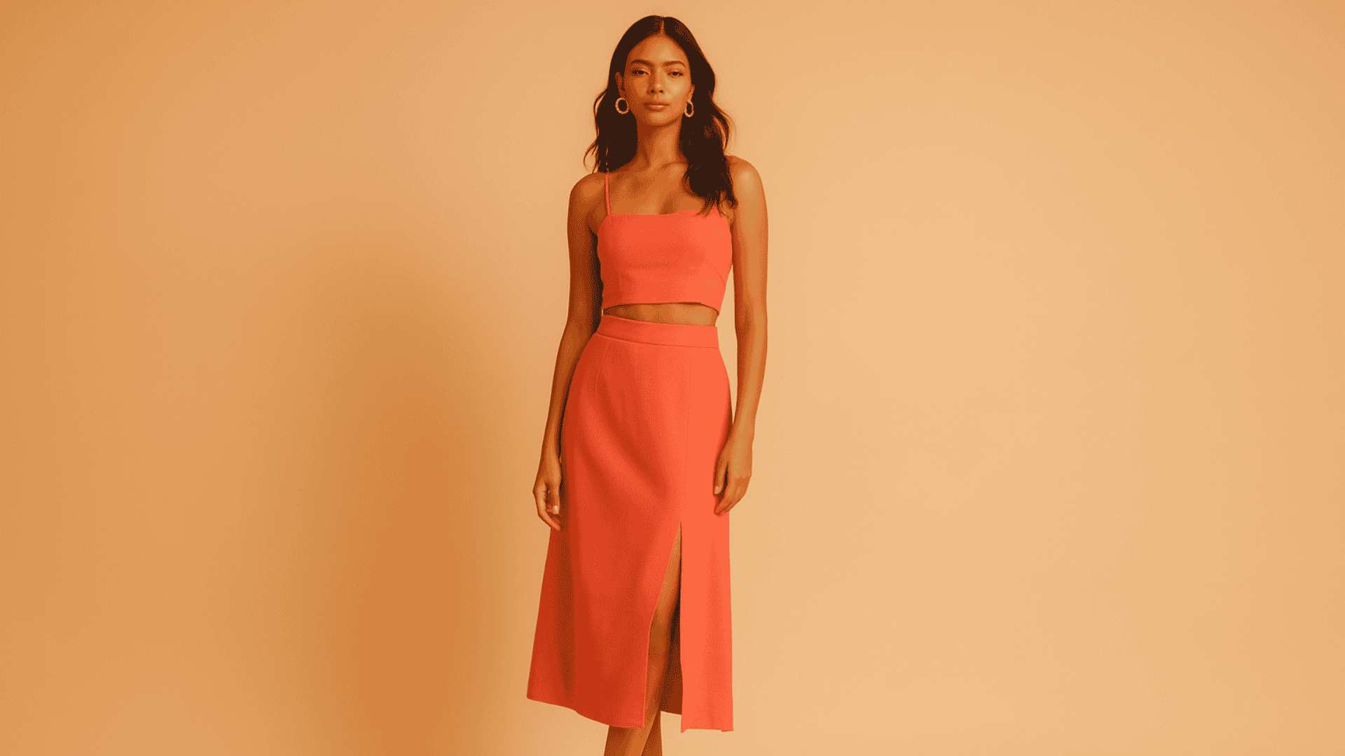 Mujer morena con un top y falda coral.