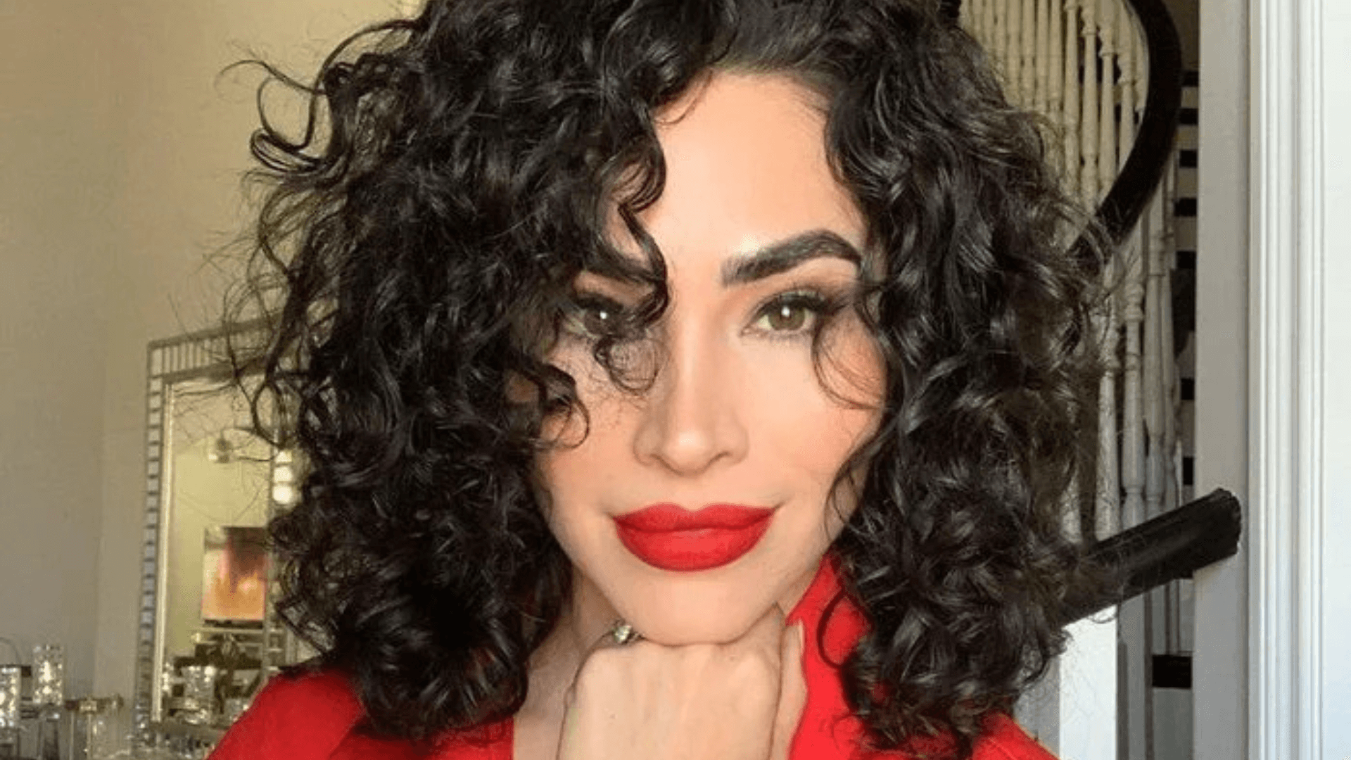 Mujer con flequillo lateral rizado.