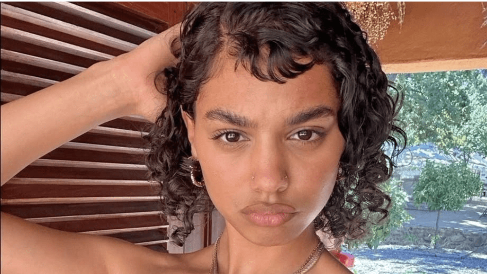 Mujer luce micro bangs rizados.