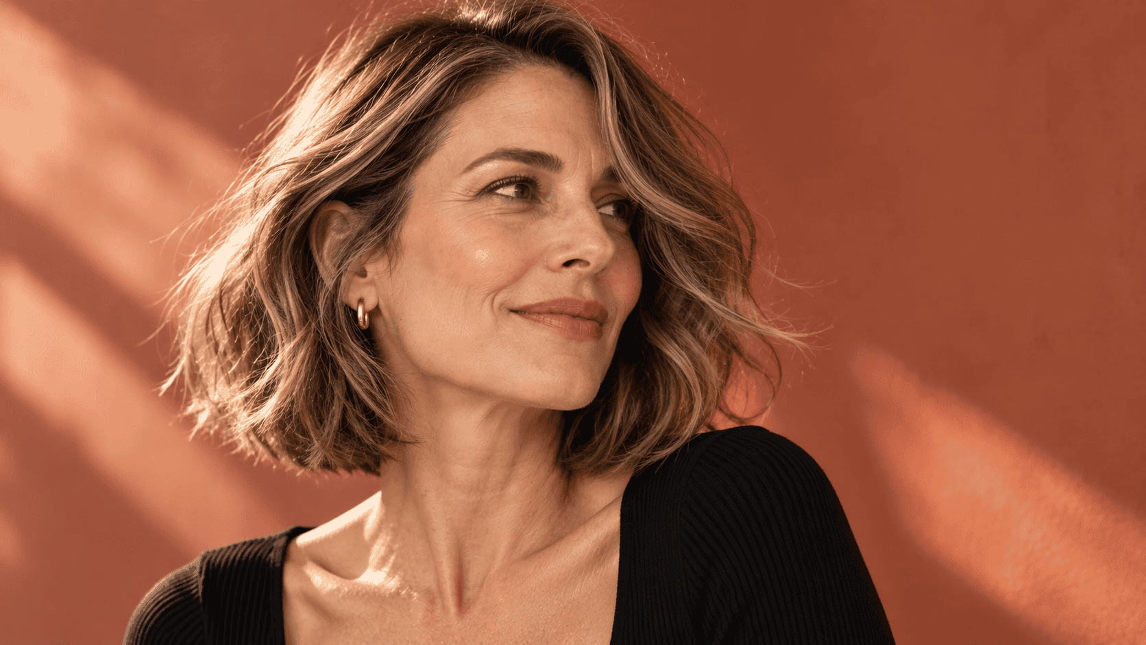 Mujer de 40 años con long bob a la altura de los hombros, capas ligeras y cabello con movimiento natural.